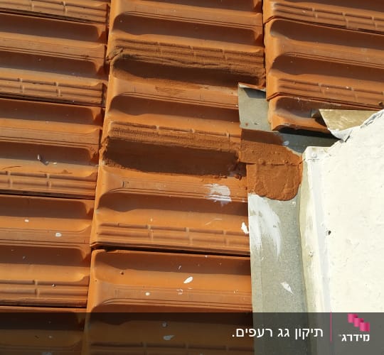 רעפים כתומים עם תיקון בטיט על הגג